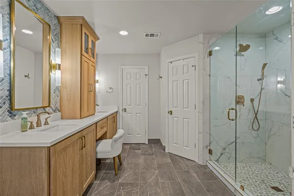 a bathroom with a double vanity sink mirror double and shower