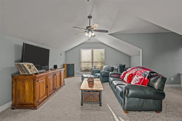 a living room with furniture a flat screen tv and a chandelier