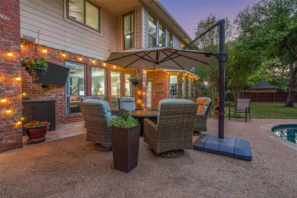 a view of a patio with a table and chairs under an umbrella