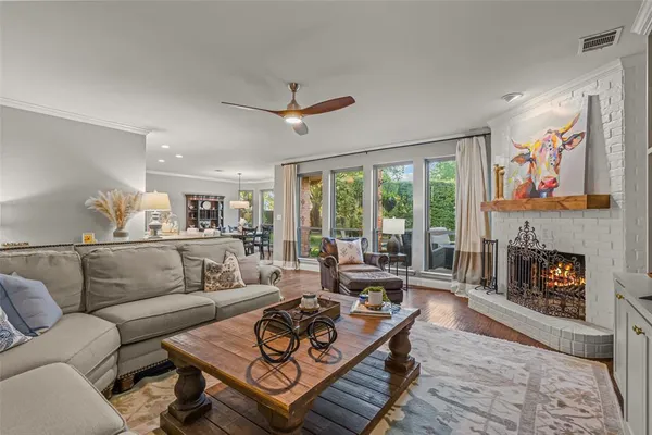 a living room with furniture a fireplace and a large window