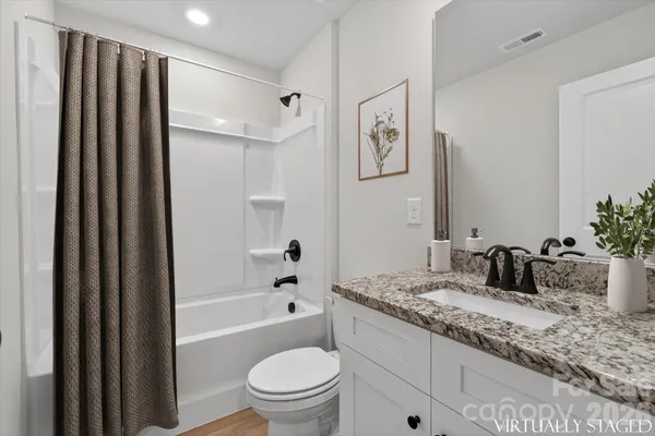 a bathroom with a granite countertop sink toilet and shower