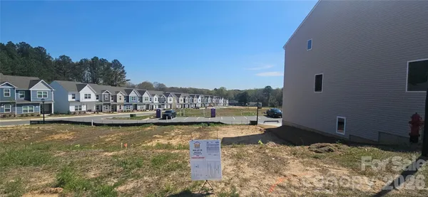 a swimming pool with lawn chairs and large tree