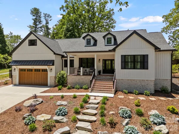 a front view of a house with a yard and potted plants
