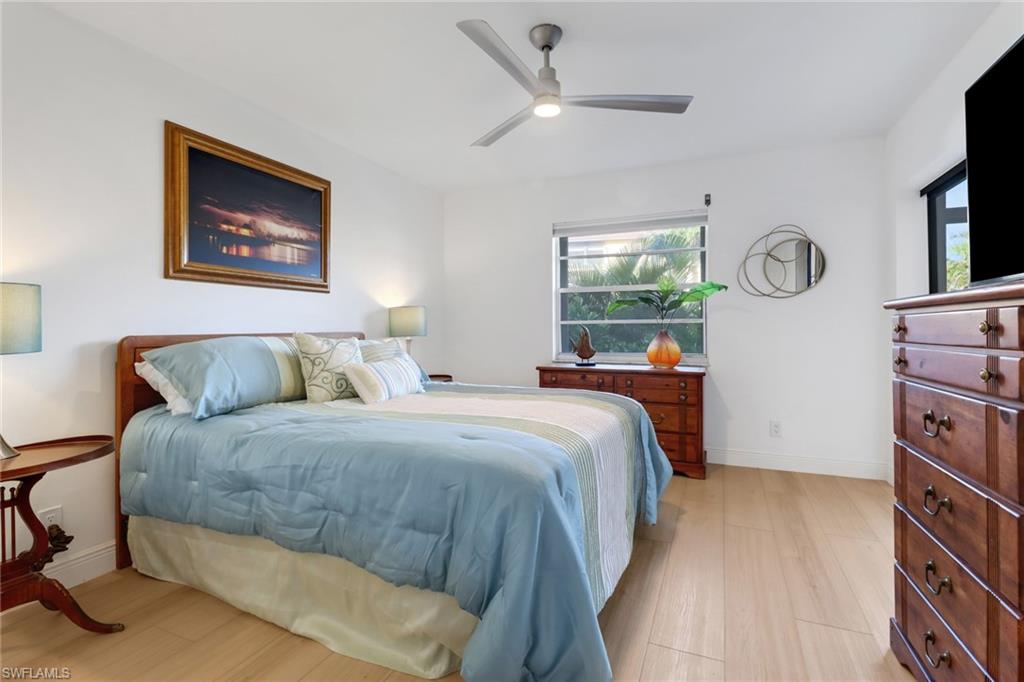 1200 Cherrystone Court, Unit A104 Naples, FL 34102 - Photo 13 of 29 Bedroom with baseboards, light wood-type flooring, and a ceiling fan