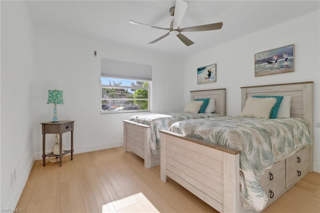 1200 Cherrystone Court, Unit A104 Naples, FL 34102 - Photo 17 of 29 Bedroom with baseboards, a ceiling fan, and light wood-type flooring