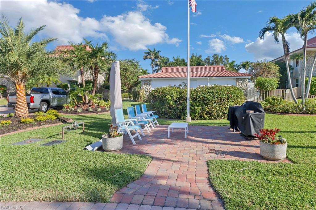 1200 Cherrystone Court, Unit A104 Naples, FL 34102 - Photo 26 of 29 View of yard featuring fence and a patio