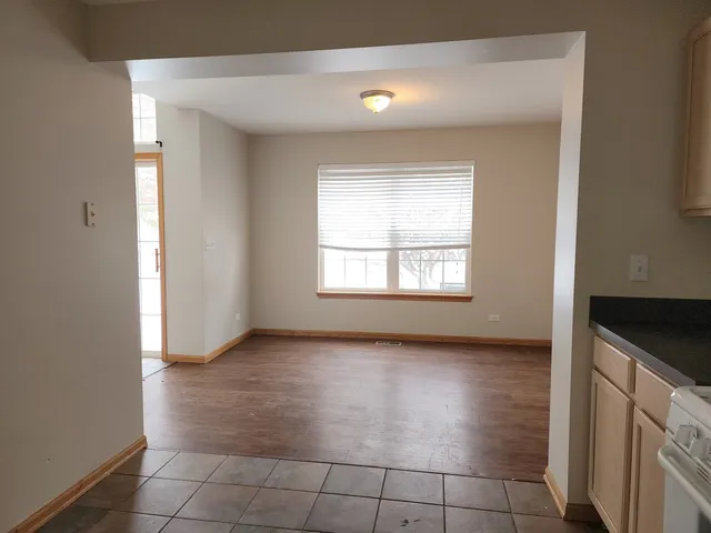 an empty room with kitchen and window