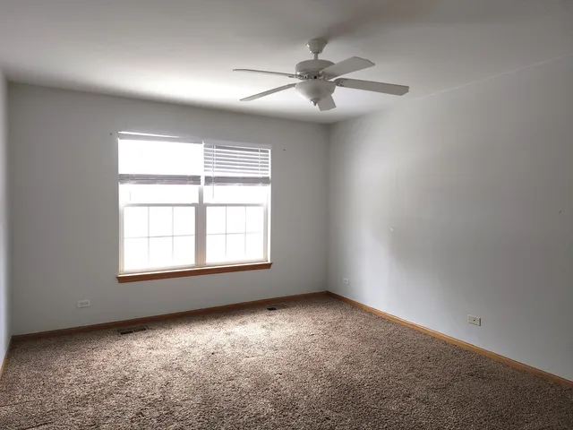 an empty room with a window and a fan