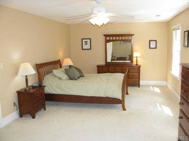 10604 Dunhill Terrace Raleigh, NC 27615 - Photo 7 of 12 a bedroom with a bed and a chandelier