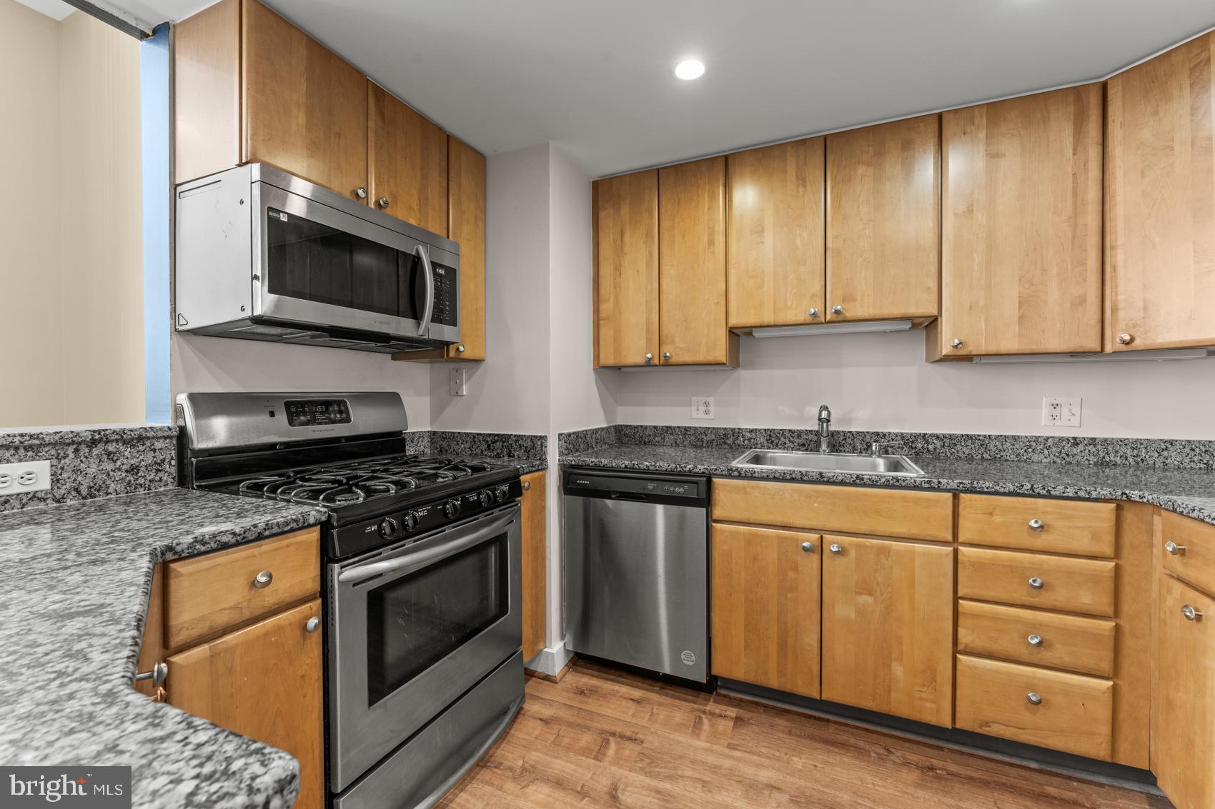 22 South Howard Street, Unit R201 Baltimore, MD 21201 - Photo 11 of 34 a kitchen with stainless steel appliances granite countertop a stove a sink and a microwave