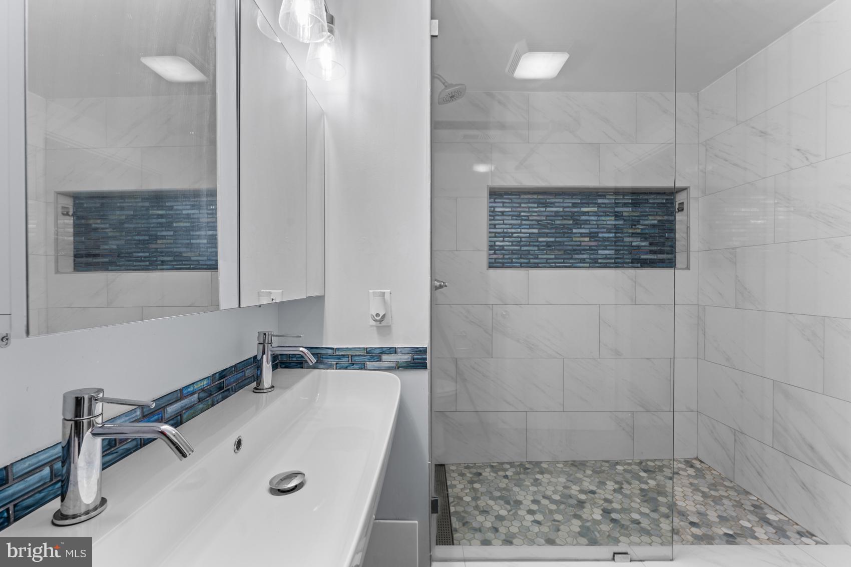 22 South Howard Street, Unit R201 Baltimore, MD 21201 - Photo 28 of 34 a bathroom with a tub a sink and a shower