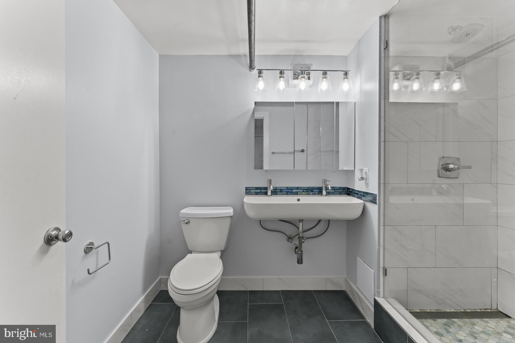 22 South Howard Street, Unit R201 Baltimore, MD 21201 - Photo 29 of 34 a bathroom with a sink a toilet and shower