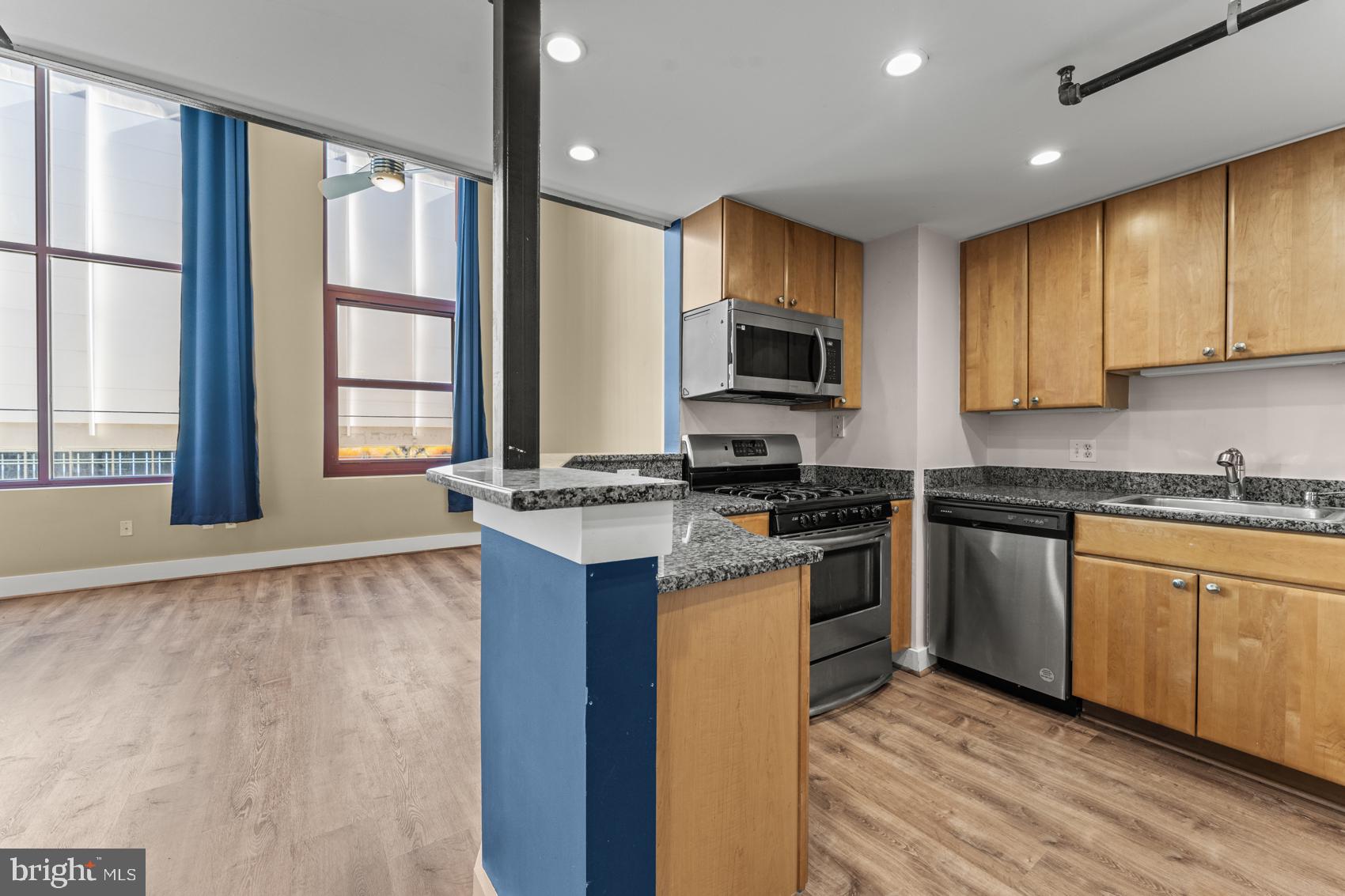 22 South Howard Street, Unit R201 Baltimore, MD 21201 - Photo 8 of 34 a kitchen with stainless steel appliances granite countertop a stove a sink and a microwave