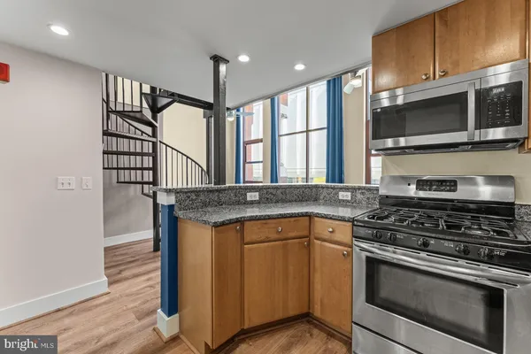 a kitchen with stainless steel appliances granite countertop a stove and a microwave