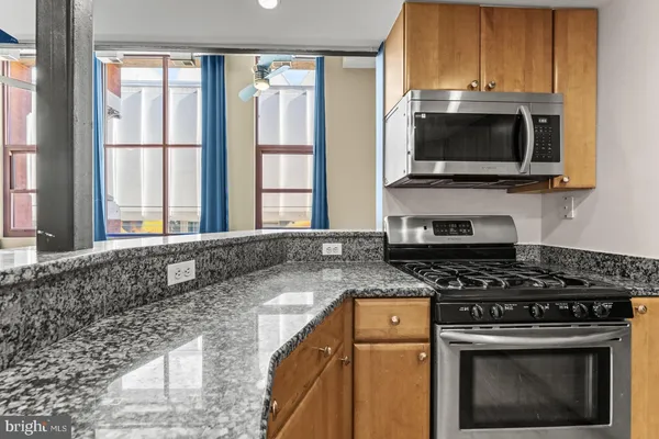 a kitchen with stainless steel appliances granite countertop a stove microwave and sink