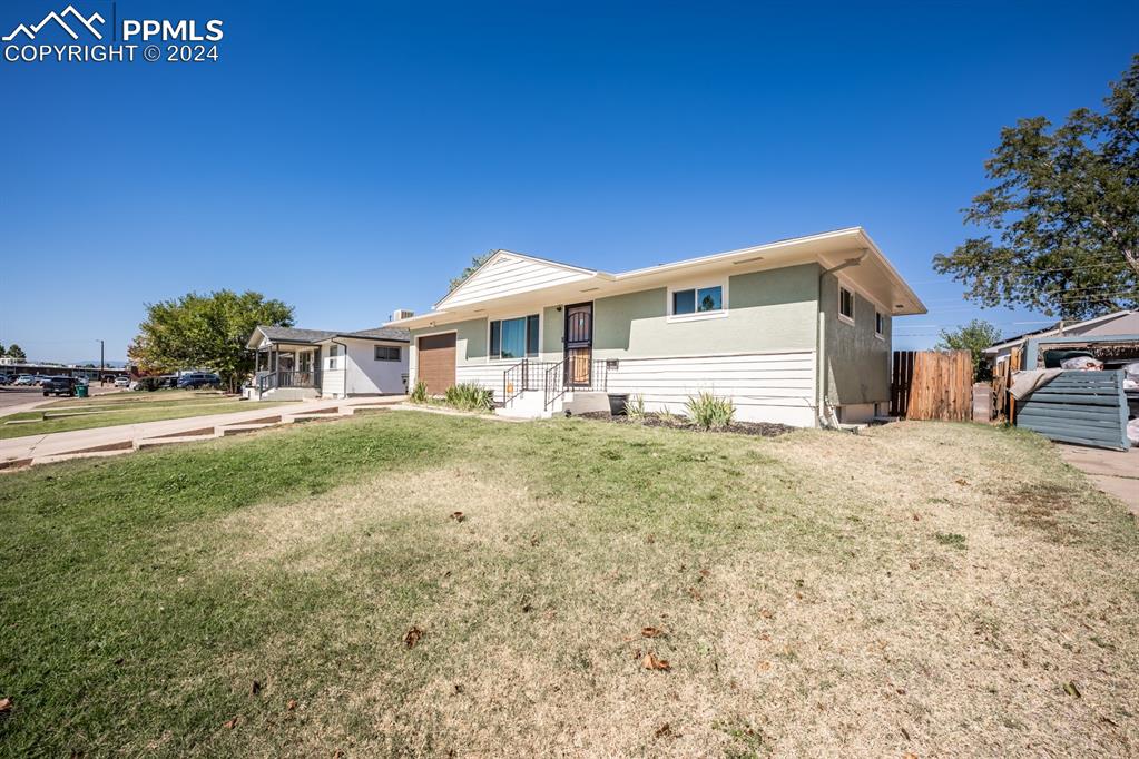 91 Duke Street Pueblo, CO 81005 - Photo 3 of 30 a front view of a house with a yard