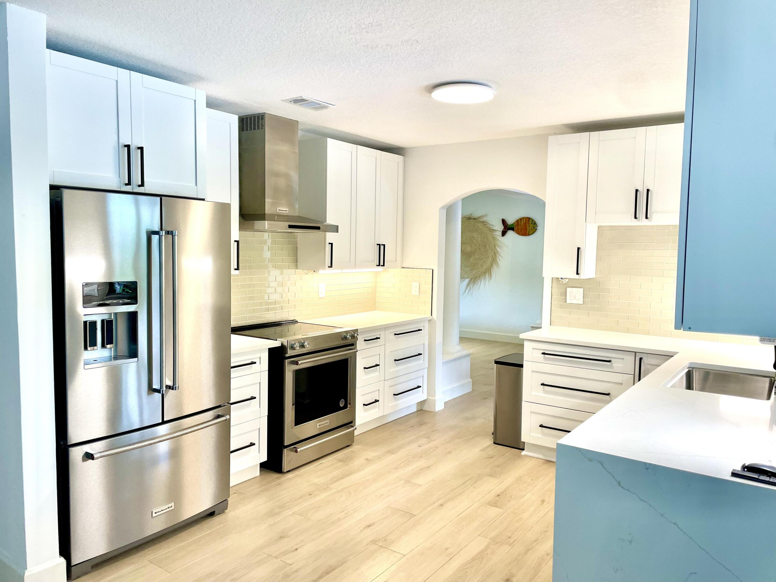 921 Northwest 7th Street Boca Raton, FL 33486 - Photo 14 of 18 a kitchen with stainless steel appliances a refrigerator sink and cabinets