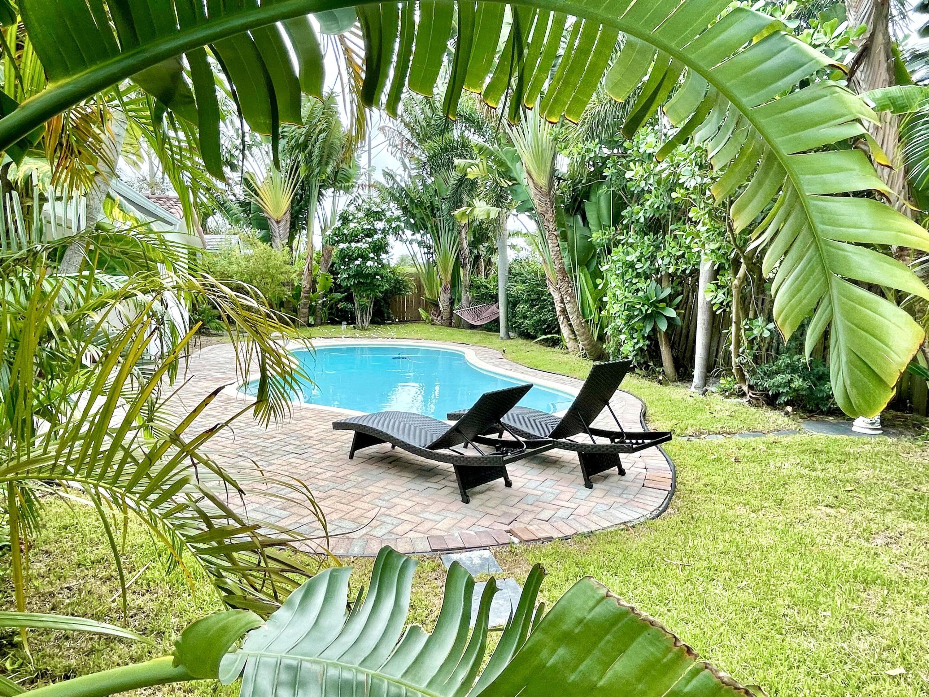 921 Northwest 7th Street Boca Raton, FL 33486 - Photo 17 of 18 a view of a swimming pool with lawn chairs and plants