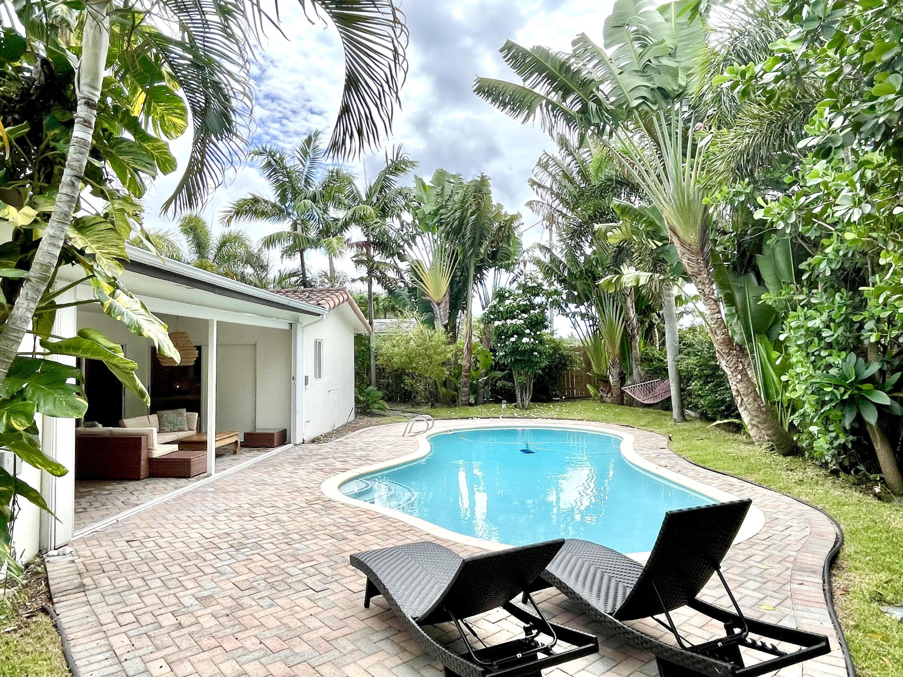 921 Northwest 7th Street Boca Raton, FL 33486 - Photo 2 of 18 a view of a swimming pool with chair and tables