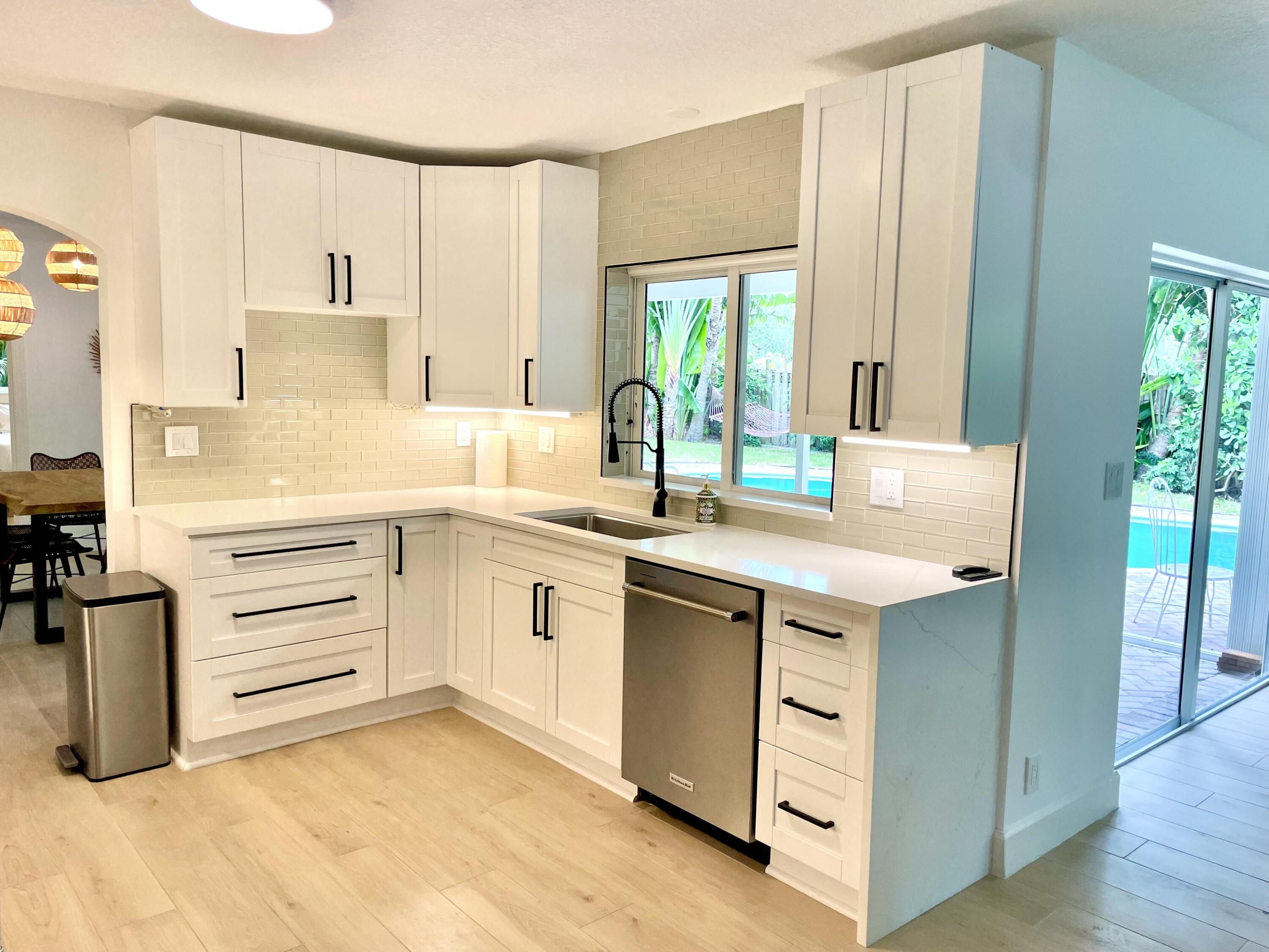 921 Northwest 7th Street Boca Raton, FL 33486 - Photo 5 of 18 a kitchen with a sink stove and cabinets