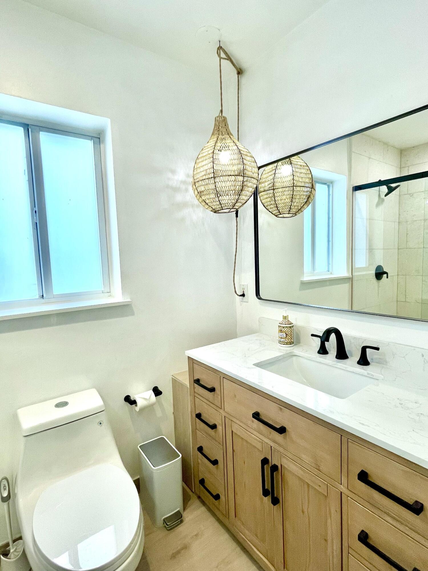 921 Northwest 7th Street Boca Raton, FL 33486 - Photo 9 of 18 a bathroom with a toilet sink and mirror