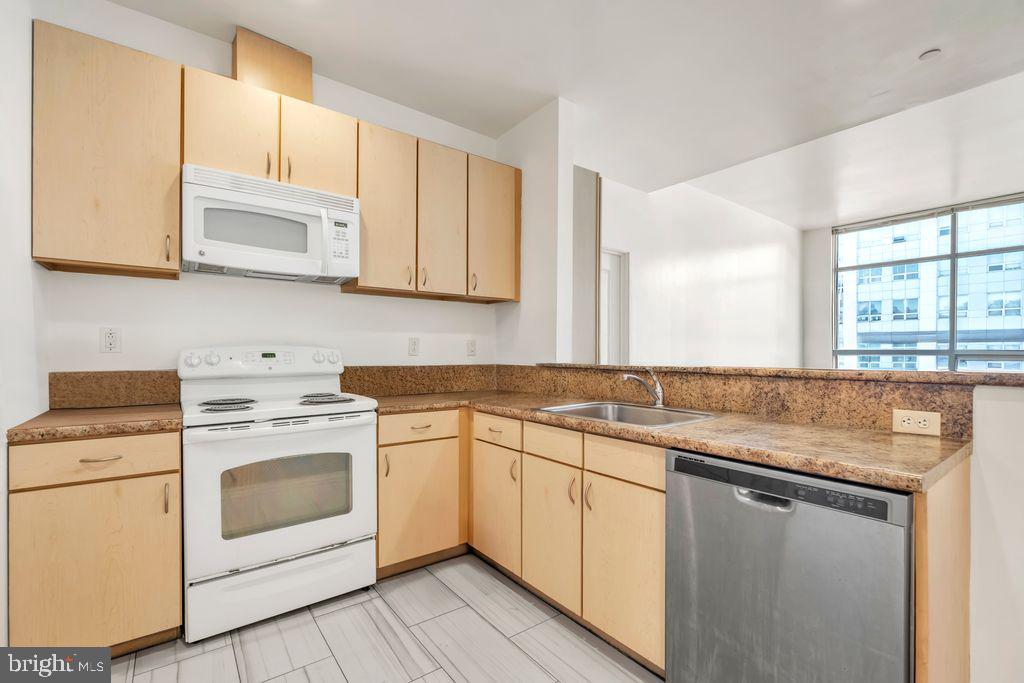 a kitchen with granite countertop white cabinets sink and white appliances