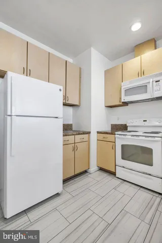 a white refrigerator freezer and a stove sitting inside of a kitchen