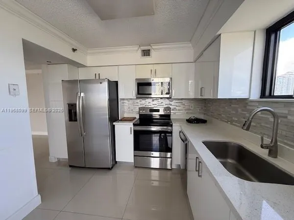 a kitchen with a refrigerator sink and microwave