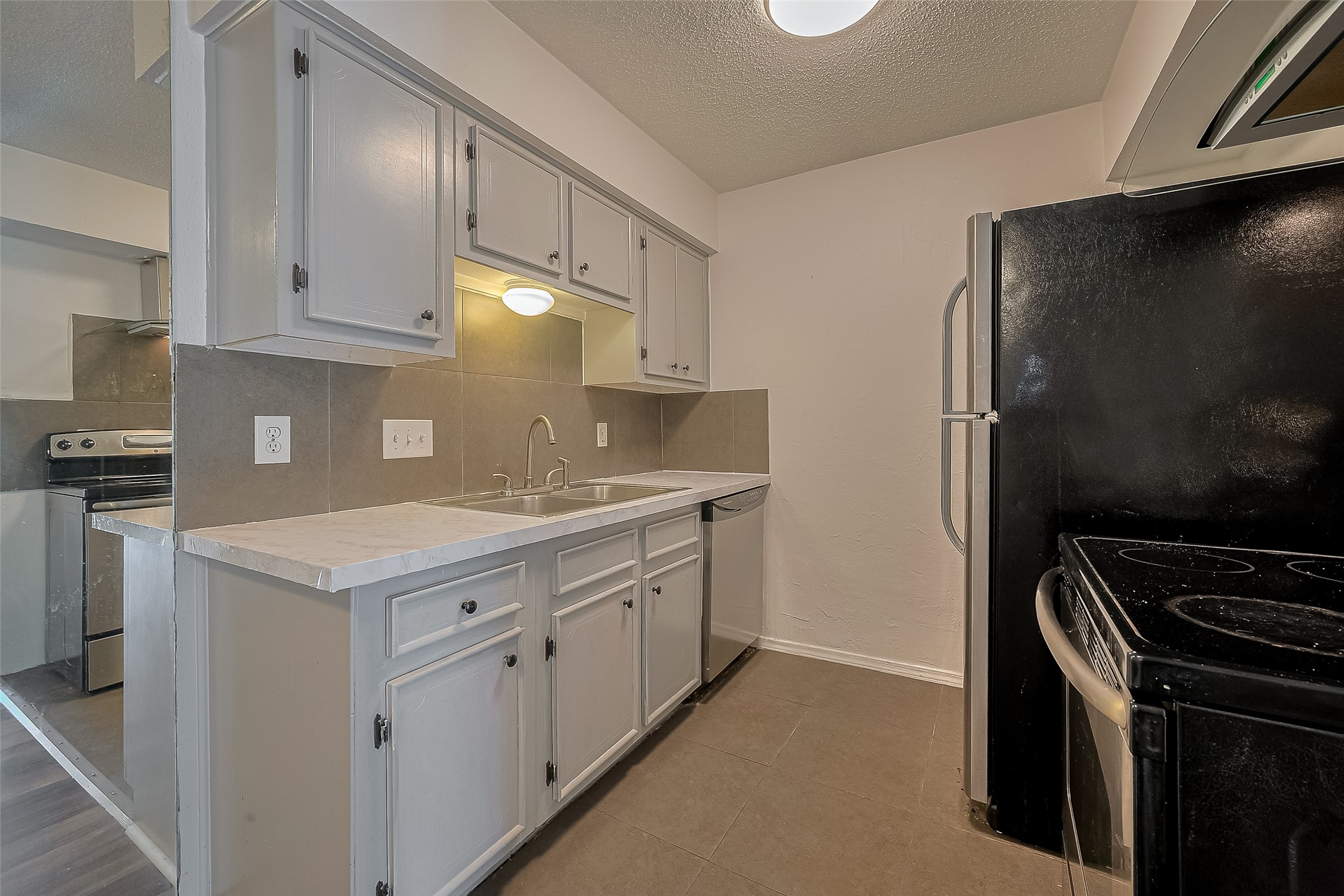 606 Marshall Street, Unit 35 Houston, TX 77006 - Photo 4 of 13 a kitchen with a sink stove and refrigerator