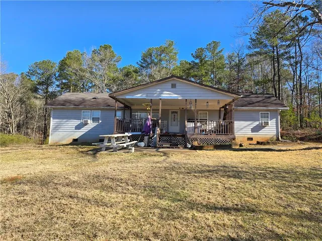 a view of a house with backyard and sitting area