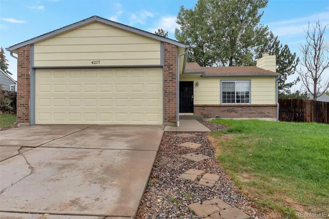 a view of house with a yard and garage