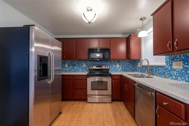 a kitchen with stainless steel appliances granite countertop a stove a sink and a microwave