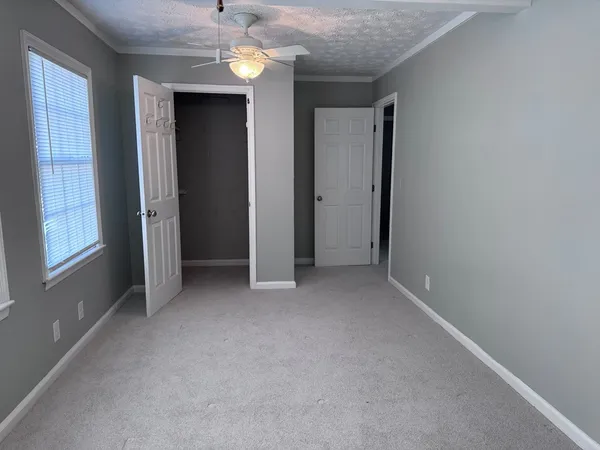 an empty room with windows and closet