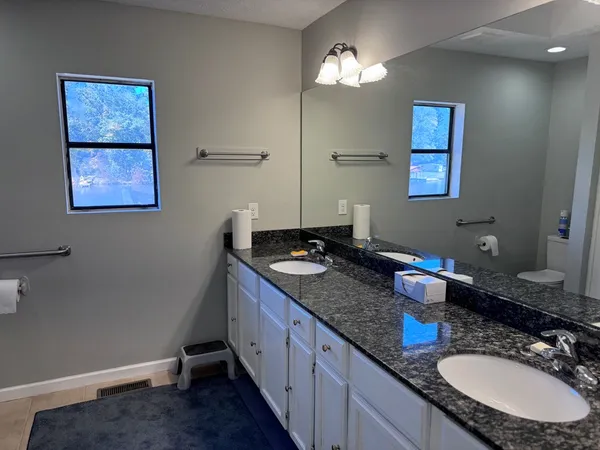 a bathroom with a granite countertop sink a mirror and vanity