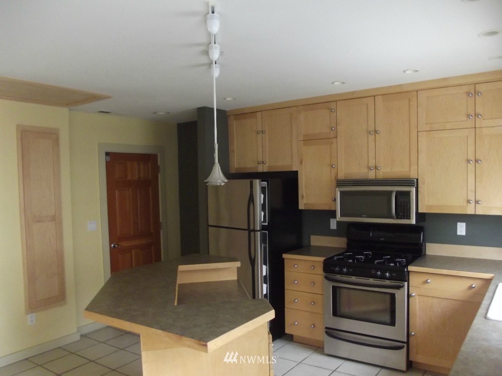 3725 Rockefeller Avenue Everett, WA 98201 - Photo 9 of 24 a kitchen with kitchen island granite countertop a stove a refrigerator and a sink
