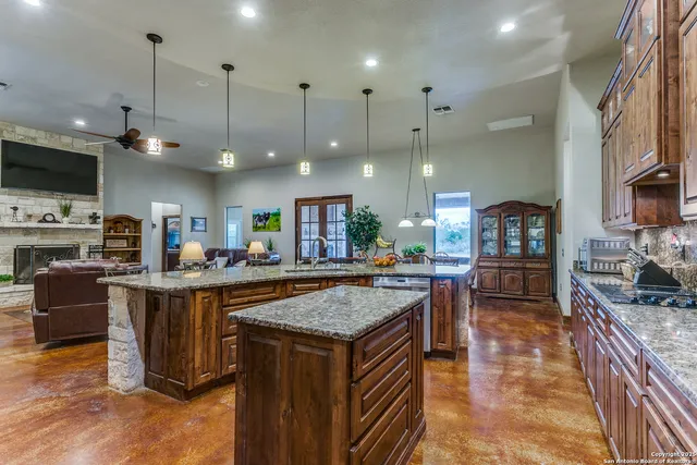 a kitchen with stainless steel appliances granite countertop a stove a sink a oven a dining table and chairs
