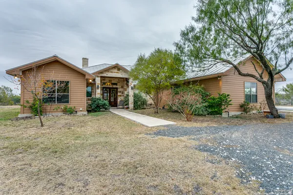 a view of a house with a yard and large tree