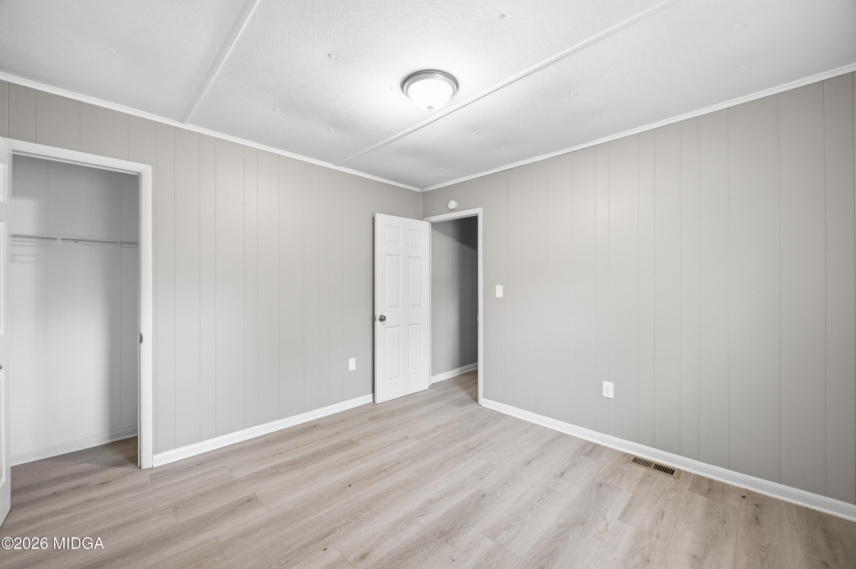 427 Gun Club Road Fort Valley, GA 31030 - Photo 20 of 26 an empty room with wooden floor and windows