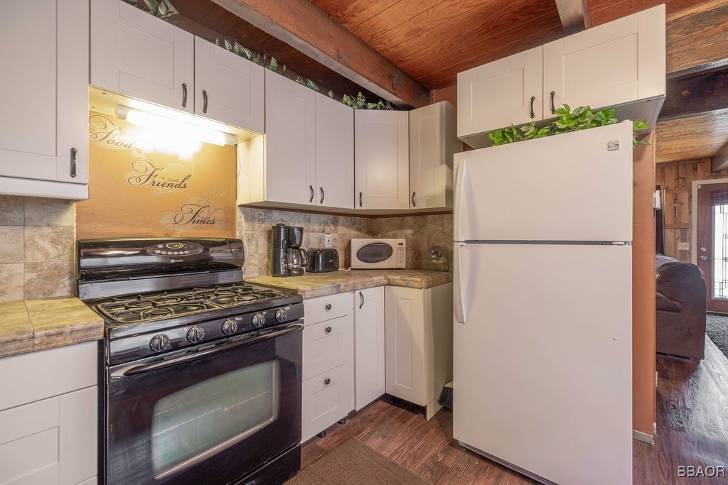 548 Riverside Avenue Sugarloaf, CA 92386 - Photo 15 of 37 a kitchen with a stove a refrigerator and a white cabinets