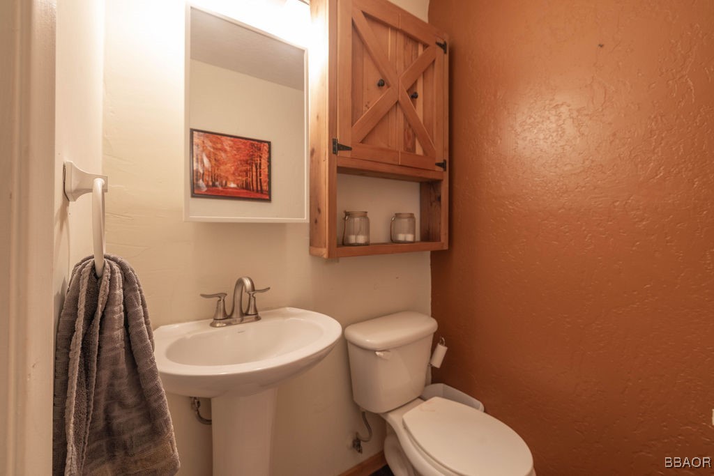 548 Riverside Avenue Sugarloaf, CA 92386 - Photo 18 of 37 a bathroom with a toilet sink and mirror