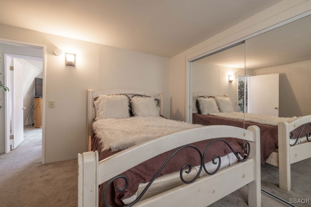 548 Riverside Avenue Sugarloaf, CA 92386 - Photo 26 of 37 a bedroom with a bed and a mirror