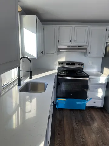 a kitchen with stainless steel appliances a stove a sink and a microwave