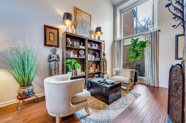 a living room with furniture a bookshelf and a potted plant