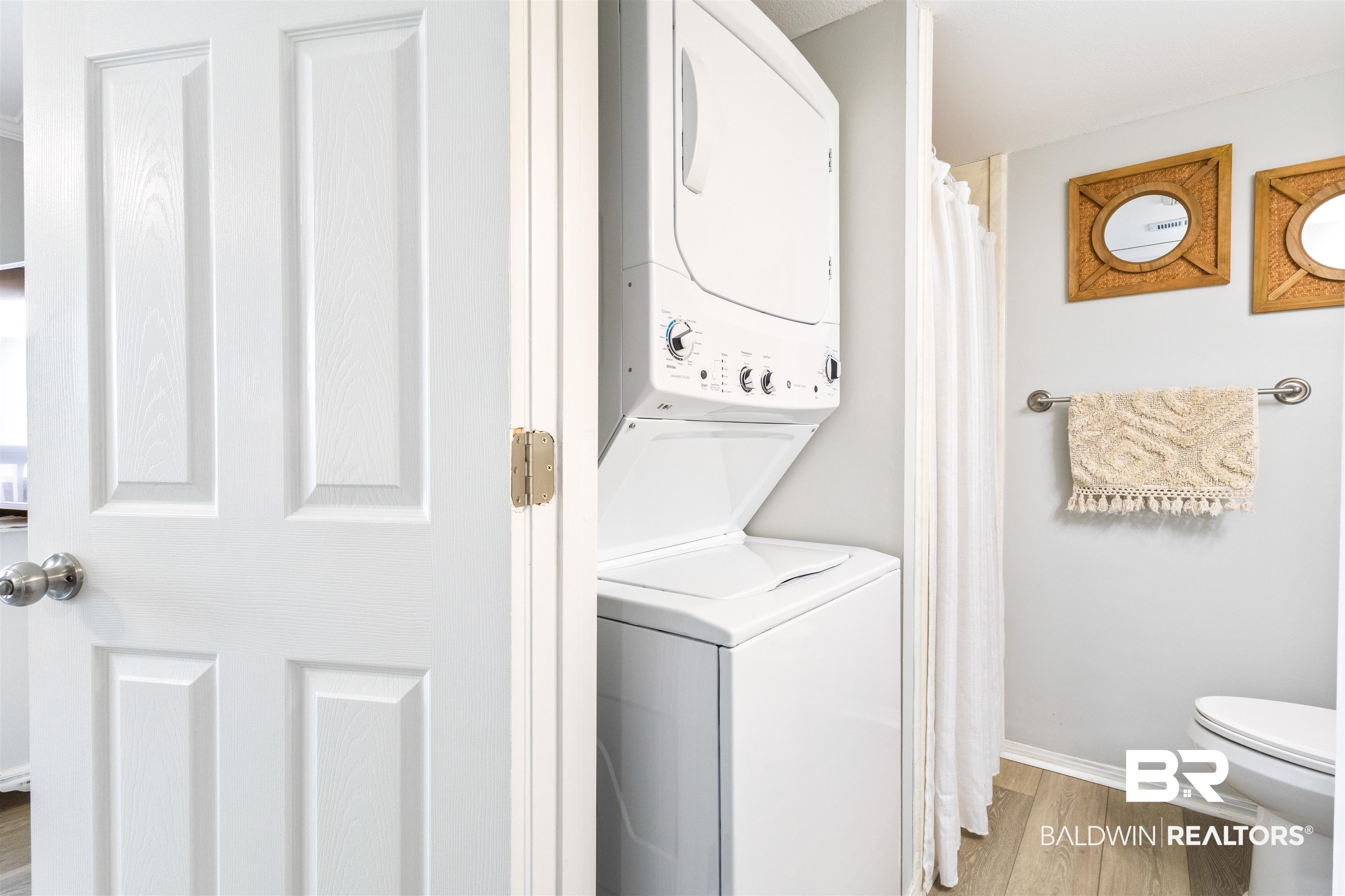 25861 Canal Road, Unit 3 Orange Beach, AL 36561 - Photo 17 of 40 Laundry area featuring stacked washing machine and dryer and wood finished floors