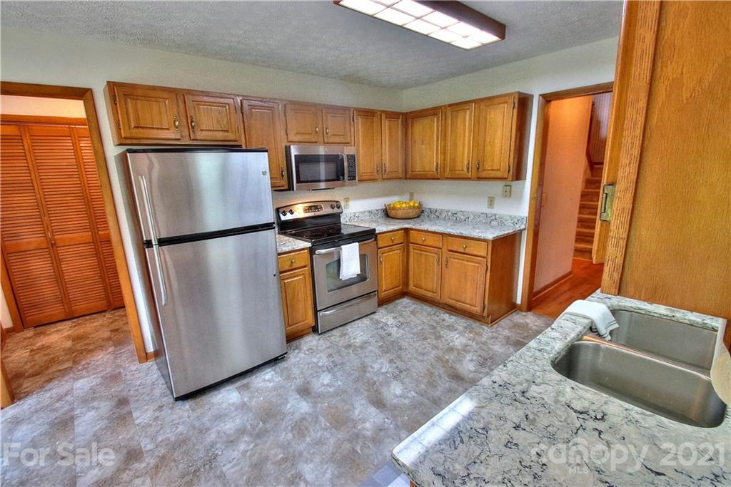 304 Oak Ridge Drive Clyde, NC 28721 - Photo 5 of 31 a kitchen with stainless steel appliances granite countertop a refrigerator stove microwave and sink