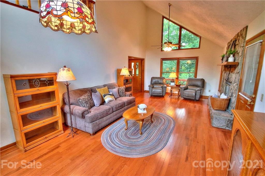304 Oak Ridge Drive Clyde, NC 28721 - Photo 10 of 31 a living room with furniture a fireplace and a large window