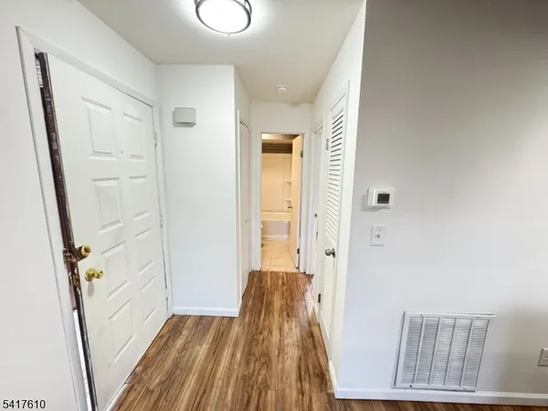 a view of a hallway with wooden floor and staircase