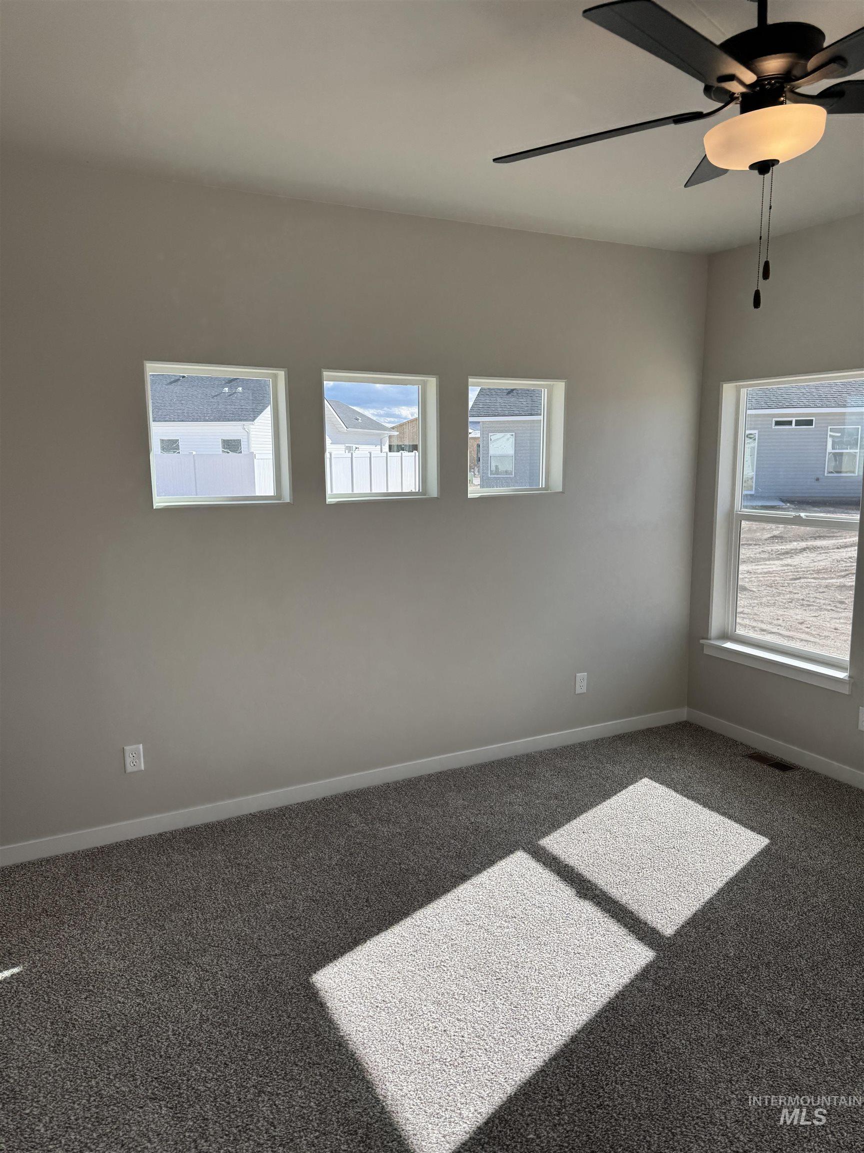 2064 Harrison Street South Twin Falls, ID 83301 - Photo 13 of 29 Empty room featuring a ceiling fan, carpet flooring, and healthy amount of natural light