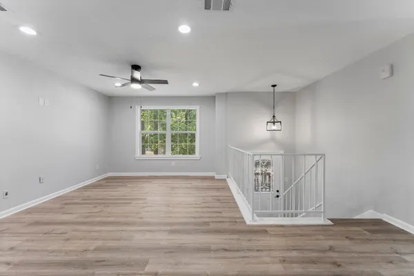 an empty room with wooden floor and windows