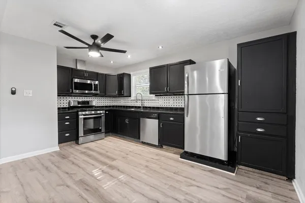 a kitchen with stainless steel appliances granite countertop a refrigerator stove a sink and dishwasher